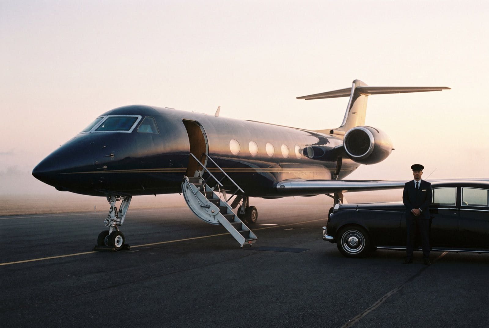 Private jet and waiting car at dawn